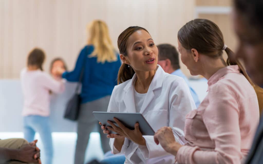 A doctor talking with a patient using a tablet that contains the patient’s medical records