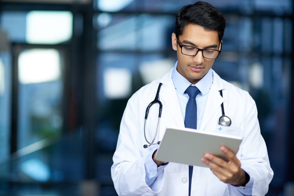 Doctor reviews patient data on an iPad, supporting accurate patient matching.