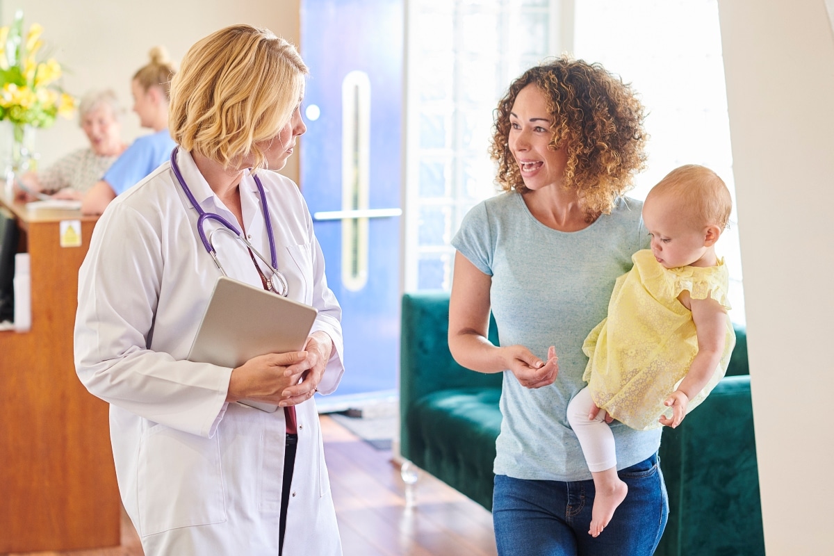 A pediatrician reviews a baby's wellness visit with mom, closing the care gap.
