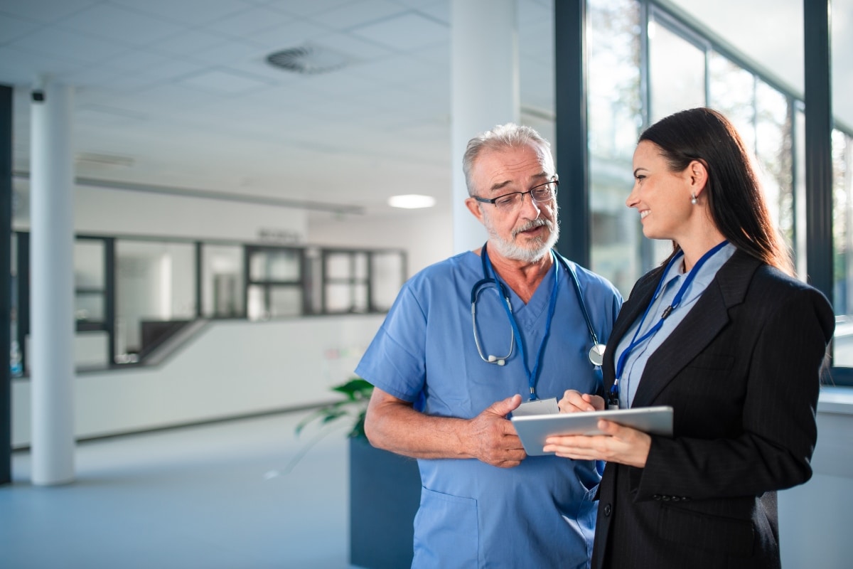 A healthcare provider and administrative staff review provider credentialing data together.