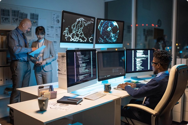 An IT professional codes while leaders discuss their digital transformation roadmap.