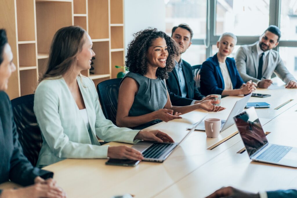 A confident presenter shows the results of an identity resolution initiative to her team.