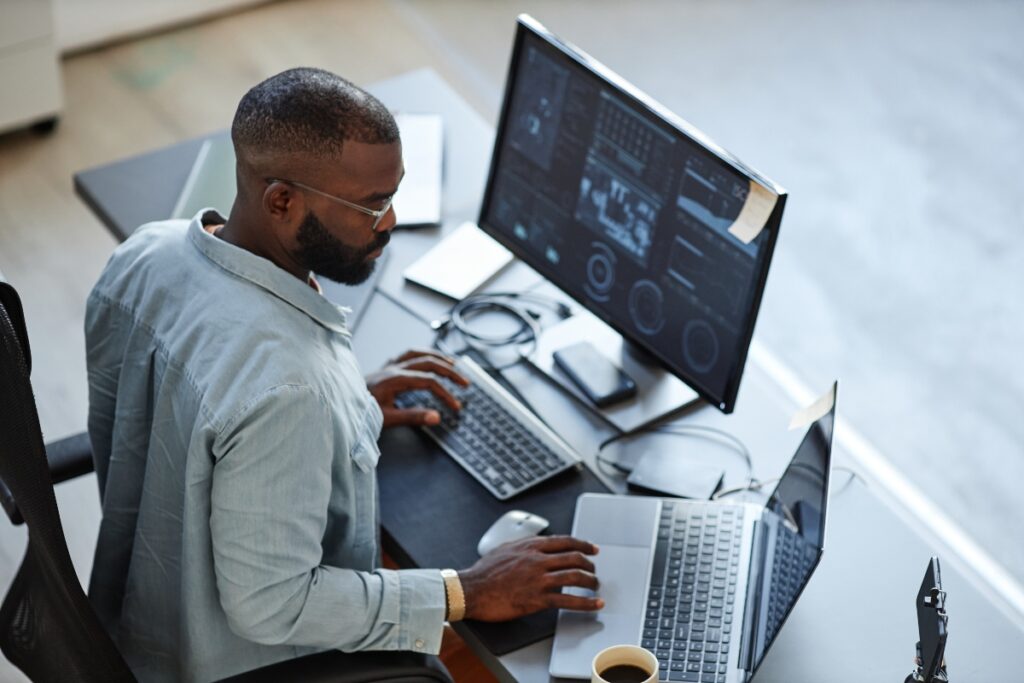 A researcher reviews patient and HCP data across multiple monitors.