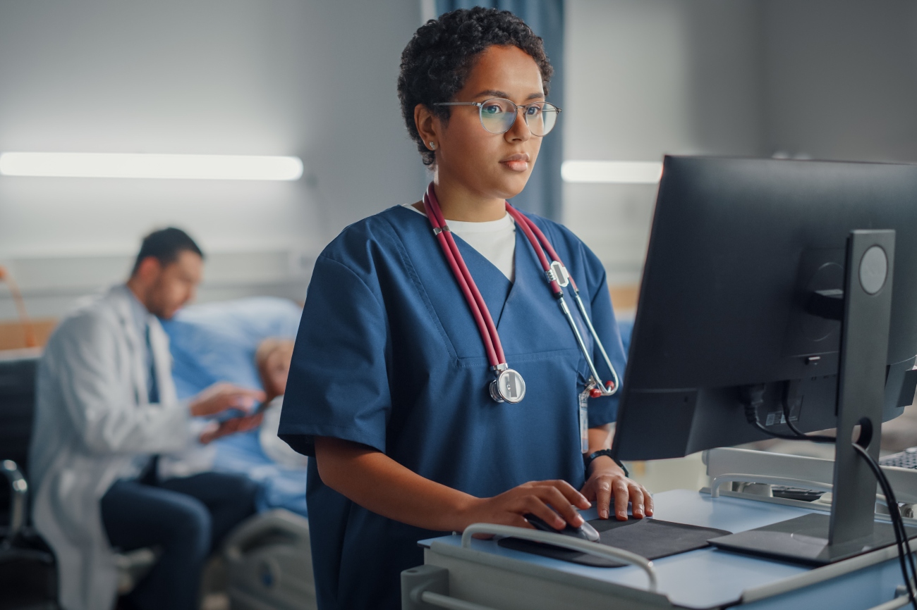A nurse at a bedside computer pulls up the right record through accurate patient matching.